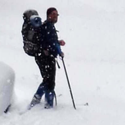 Staff insights - Jeff and backcountry skiing: Jeff hiking through deep snow with a backpack on.