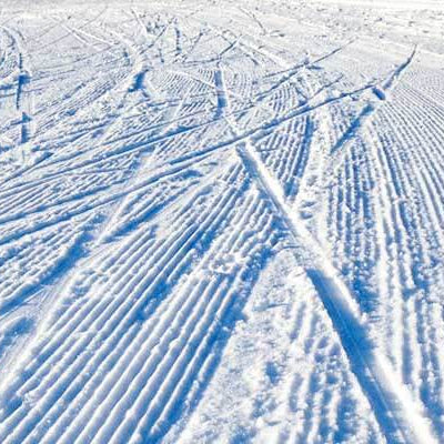 Eb's Ski Tip: flat skis are fast skis - ski tracks on a snowy surface from flat skis.