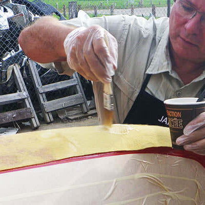 Person applying skid plates to a canoe, demonstrating how to apply skid plates for protection.