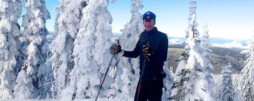 Review: Salomon RC Skin Waxless Skis in a snowy landscape with a skier enjoying the winter scenery.