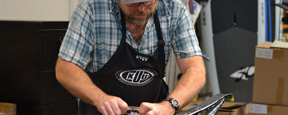 man waxing cross country skis on a bench
