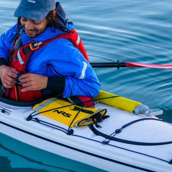 Man in a kayak putting something on his pfd