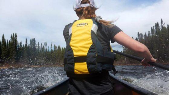 woman paddling with PFD on