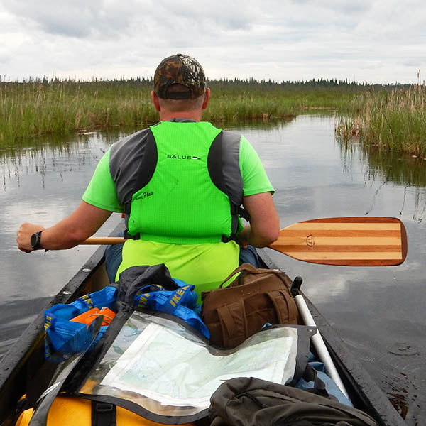 Man in a canoe wearing a green lifejacket