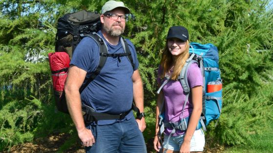 man and woman carrying packs