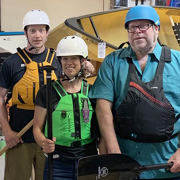 Three paddlers wearing helmets