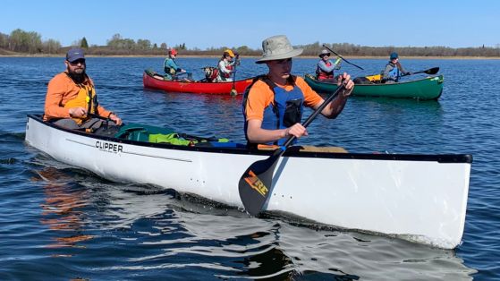 people paddling canoes