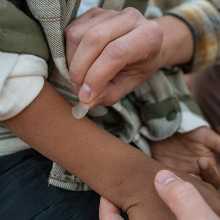 Close-up of two people holding hands, with one person wearing a plaid shirt.