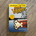 Book titled 'Journals of the New Voyageurs' by Norm Crerar on a wooden surface