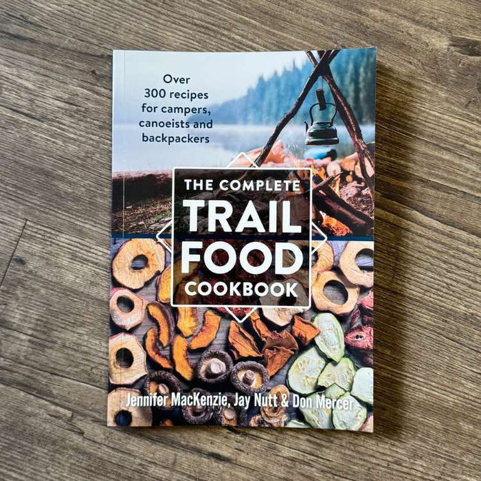 Book titled 'The Complete Trail Food Cookbook' on a wooden surface