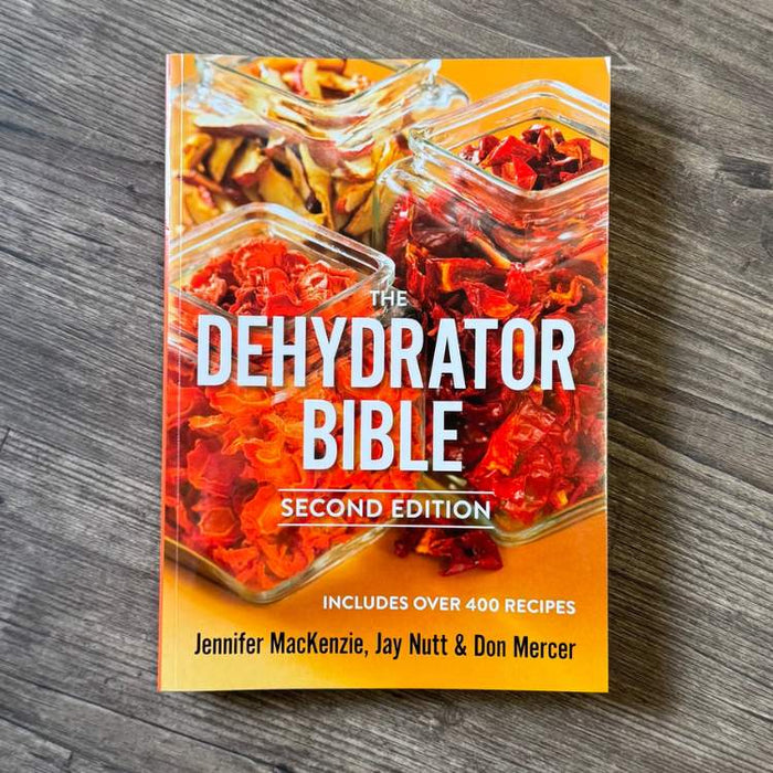 Book titled 'The Dehydrator Bible' on a wooden surface