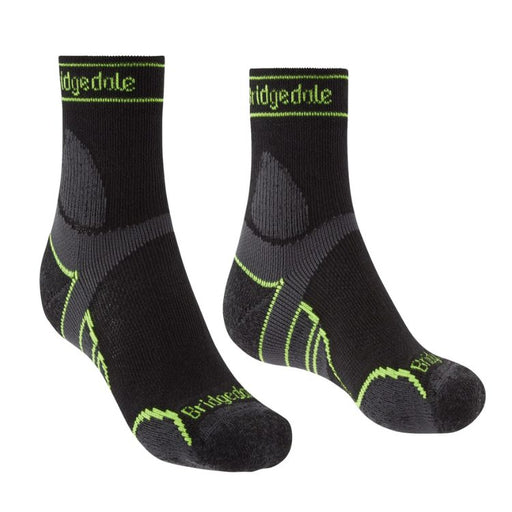 Pair of black socks with green accents and 'Bridgedale' branding on a white background