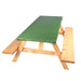 A wooden picnic table with a green padded top cushion, isolated on a white background.