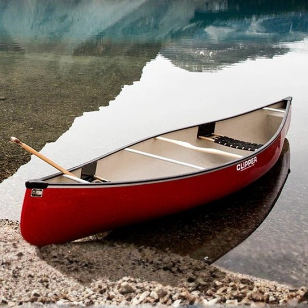 red canoe pulled up on a rocky beach