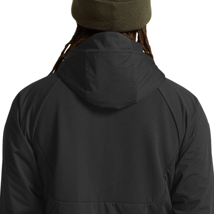 Person wearing a black jacket with a hood on a white background