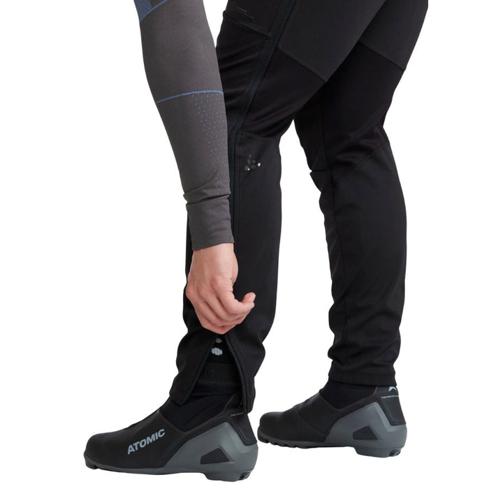 Person wearing black pants and shoes with 'Atomic' branding on a white background