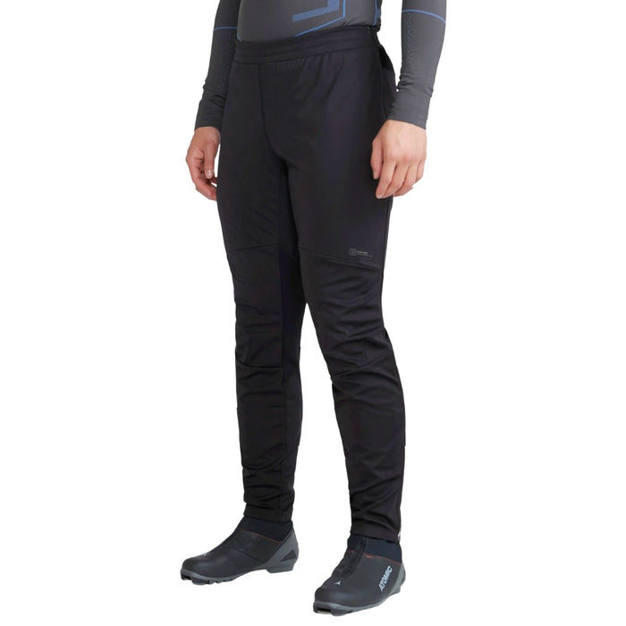 Person wearing black pants and black shoes on a white background