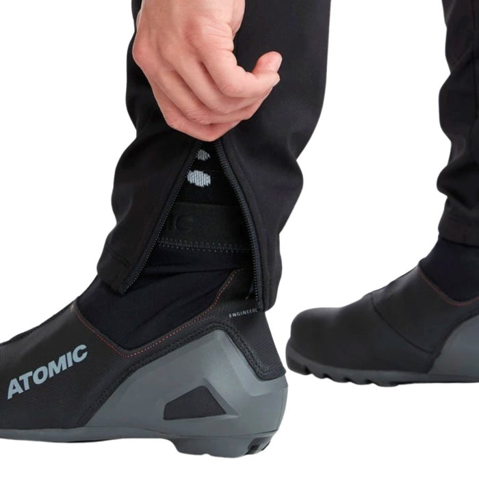 Person wearing black shoes with 'Atomic' branding on a white background