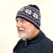 Man wearing a patterned knit hat on a white background