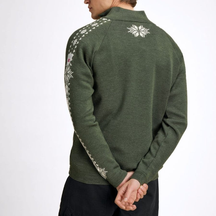 A man wearing an olive green knit sweater with white Nordic-style snowflake and geometric patterns on the shoulders and sleeves, shown from a rear three-quarter angle against a plain white background.
