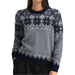 Woman wearing a grey sweater with a navy nordic pattern against a white background.