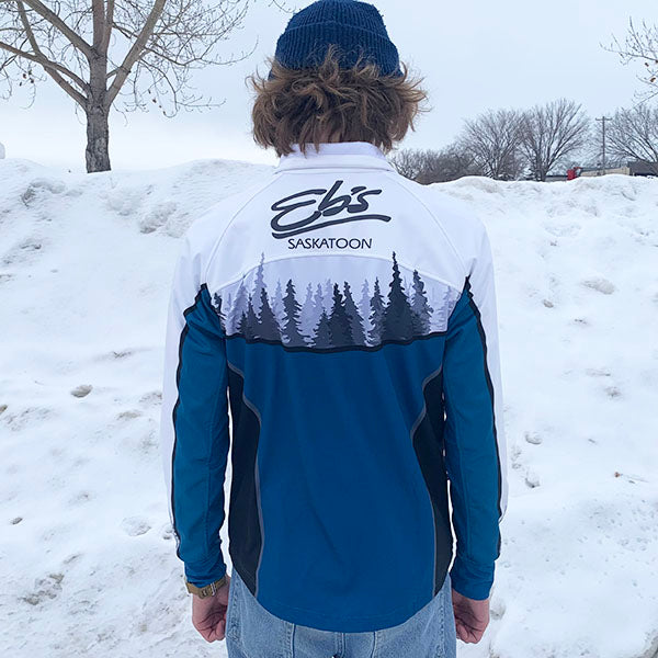 Person wearing a blue and white jacket with 'Ebs' branding in a snowy landscape