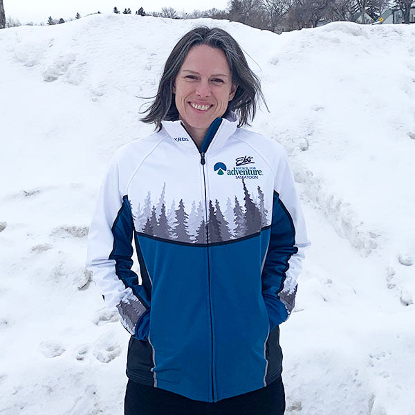 Woman wearing a blue and white jacket with a logo in a snowy landscape