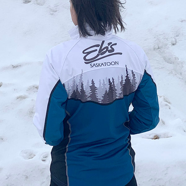 Person wearing a blue and white jacket with 'Eb's Saskatoon' branding in the snow.