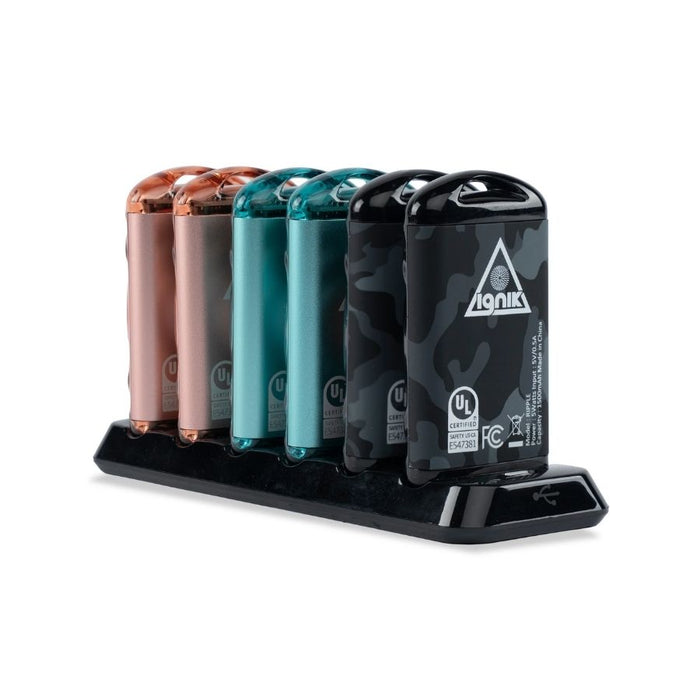 Six metal hand warmers in pink, teal and black standing on a charging dock.