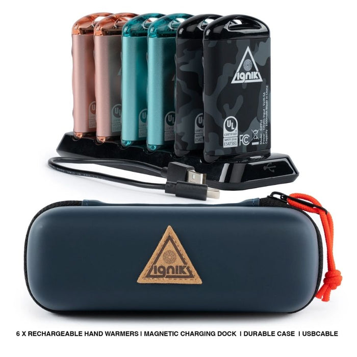 Six metal hand warmers in pink, teal and black standing on a charging dock, with a blue zipped case beside them.