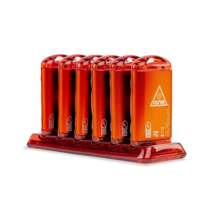 Six orange metal hand warmers standing on a charging dock.