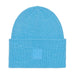 A light blue ribbed knit beanie hat with a folded cuff and a small tonal square logo patch on the front, shown against a plain white background.
