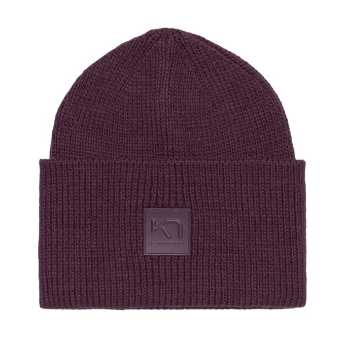 A dark plum purple ribbed knit beanie hat with a square embossed logo patch on the front cuff, shown against a plain white background.