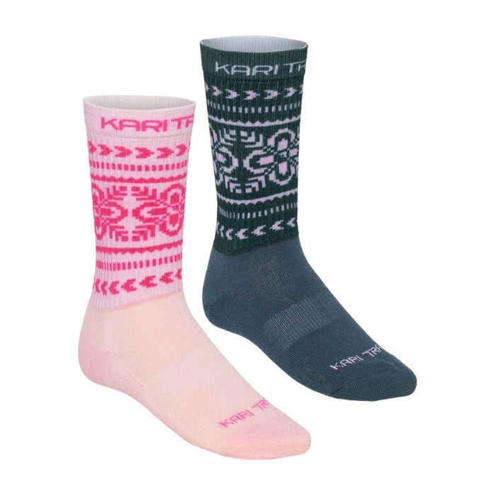 Two Kari Traa crew socks shown on a white background: one light pink with a bright pink Fair Isle pattern and cuff, and one dark teal with a white Fair Isle pattern and dark teal foot.
