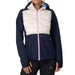 A woman wearing a colorblock hooded jacket with a navy blue lower half, a cream quilted upper panel, and a light pink front zipper. The jacket features a small white KT logo on the chest.