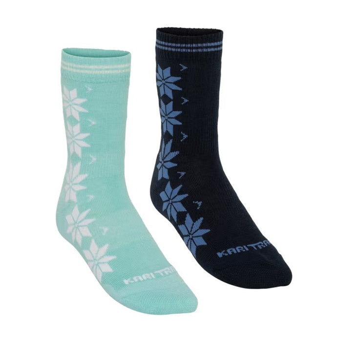 A pair of Kari Traa crew socks shown on a plain white background, featuring one mint green sock with white snowflake patterns and one black sock with blue snowflake patterns.