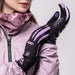 Person wearing black gloves with pink accents and a matching scarf, holding a glove up.