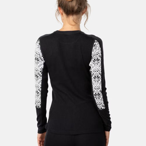 Black long-sleeve top with white nordic pattern on sleeves worn by a person on a light gray background