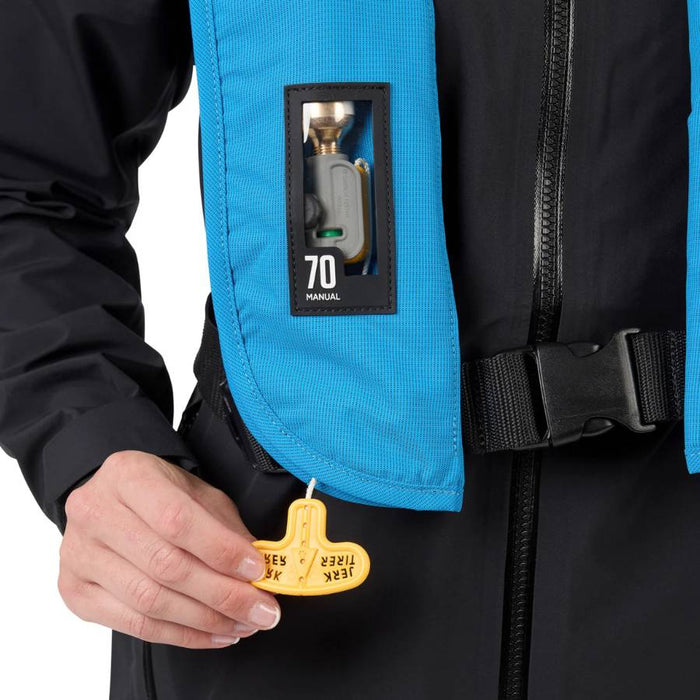 Close up of a person pulling a yellow tab attached to a blue PFD with clear window showing cartridge inside