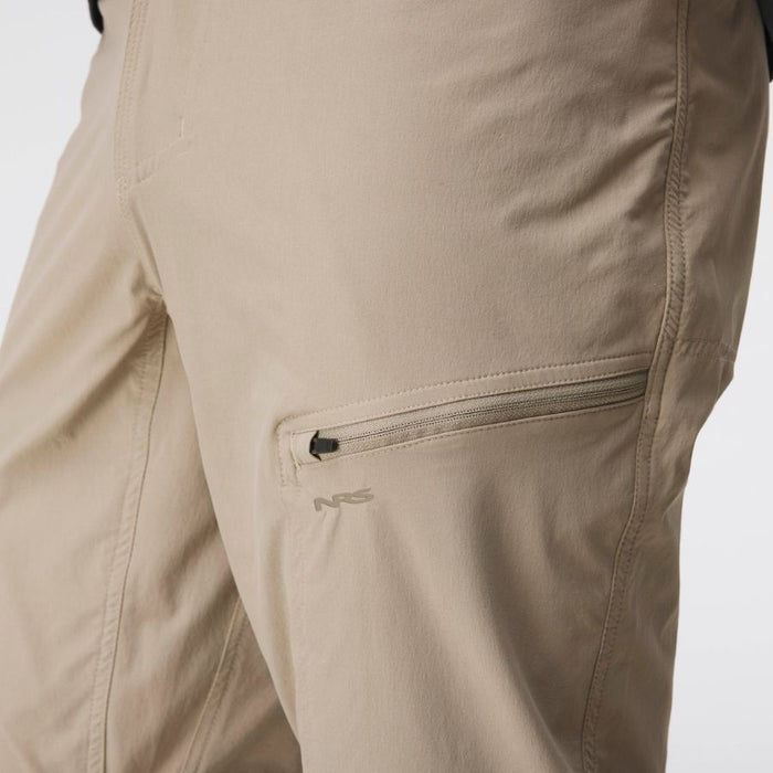 Close-up of beige technical outdoor pants showing a zippered cargo pocket with a small gray NRS logo on the thigh.
