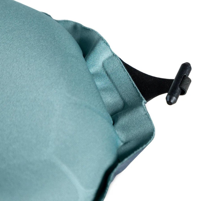 Close-up of a teal fabric with a black toggle on a white background