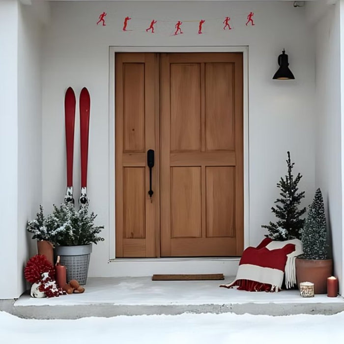 Front door with Christmas decorations including red skis, potted plants, and a blanket.