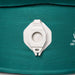 Close-up of a white plastic valve fitting attached to a teal fabric surface with partial white printed text visible on the right.