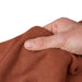 hand holding an orange towel on a white background