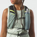 Woman wearing a light green top and running vest with flask