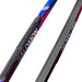 Close up of blue and pink skis with Salomon branding against a white background.