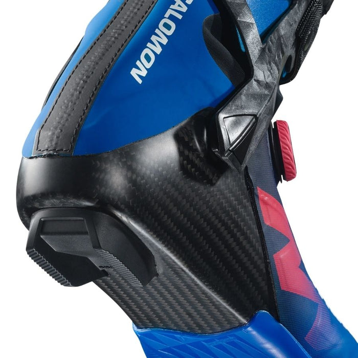 Close up of the heel of a blue, black and pink ski boot with Salomon branding against a white background.