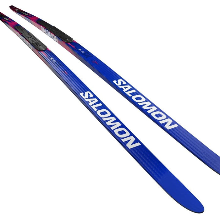 Blue and pink skis with Salomon branding against a white background.