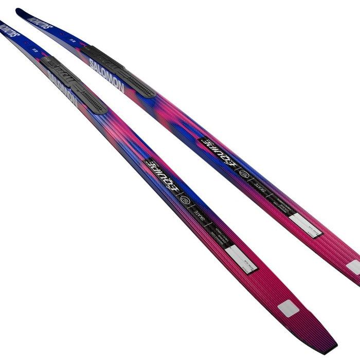 Blue and pink skis with Salomon branding against a white background.