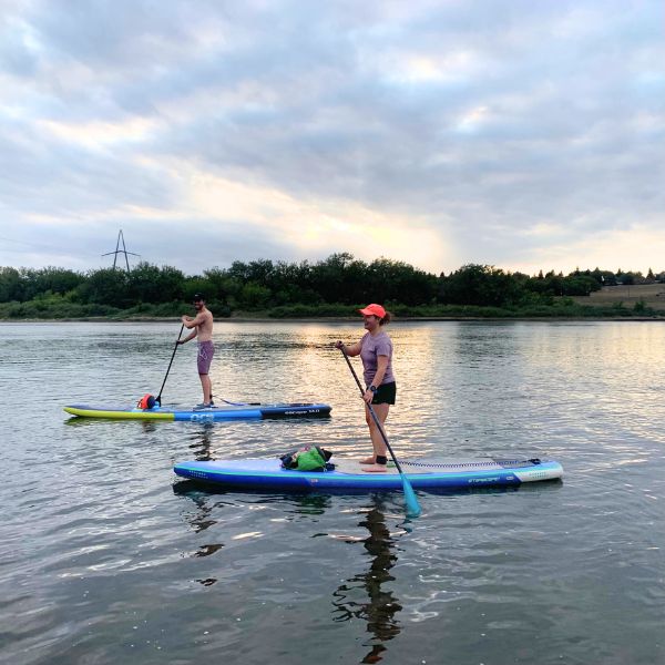 Two people on a river paddleboarding